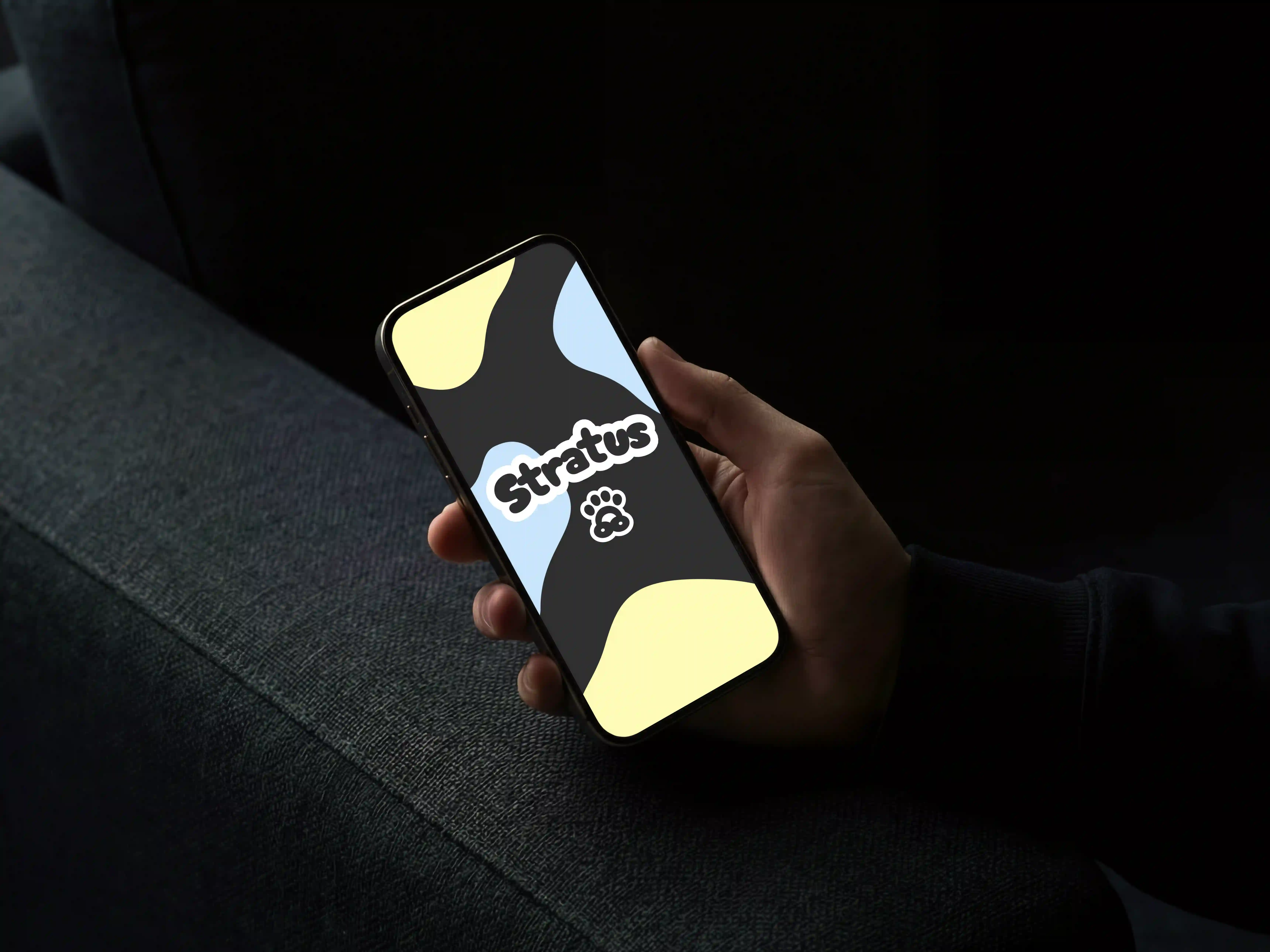 Hand som håller i en telefon som visar logotypen för väderappen Stratus